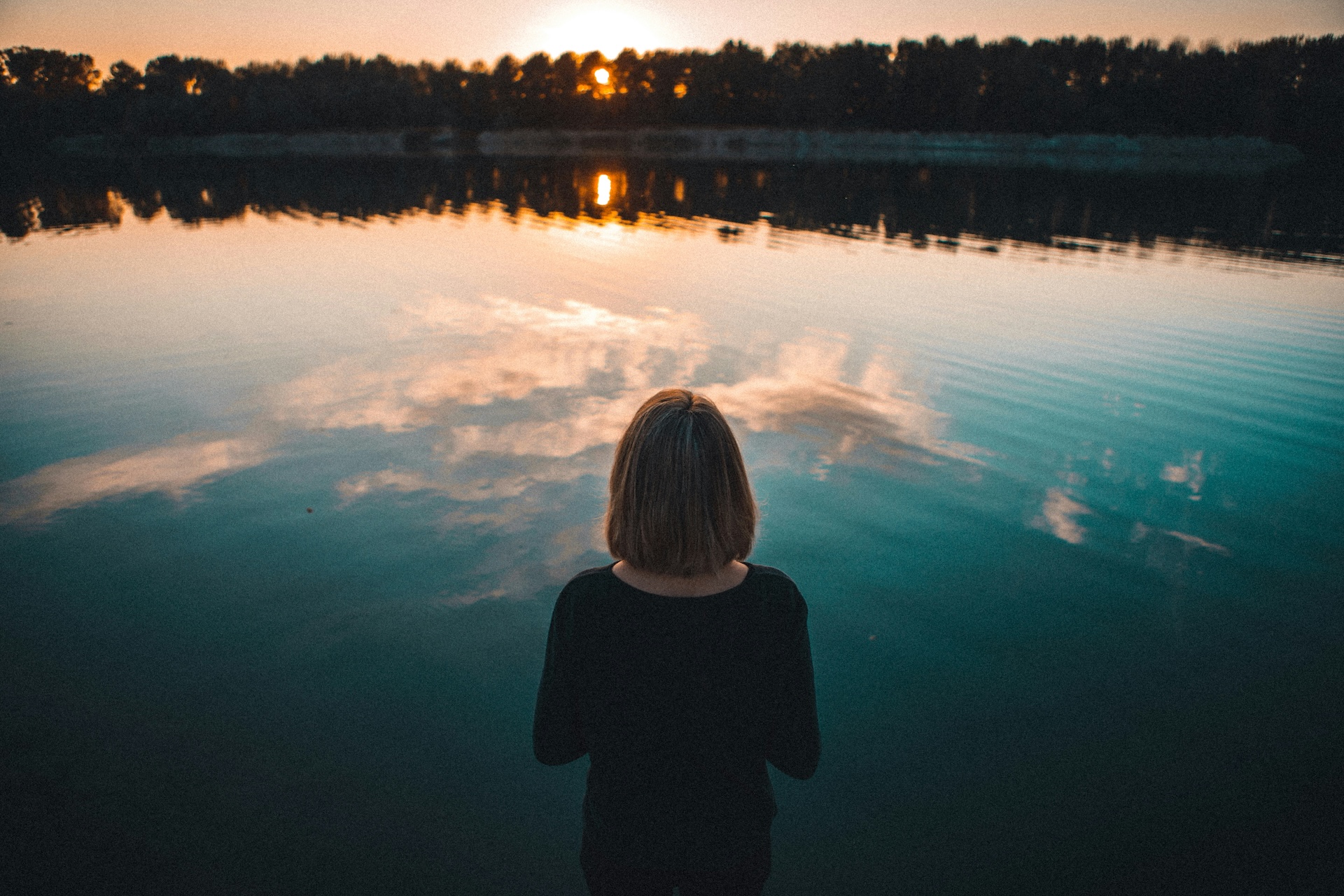 Woman reflecting on overlooking lake